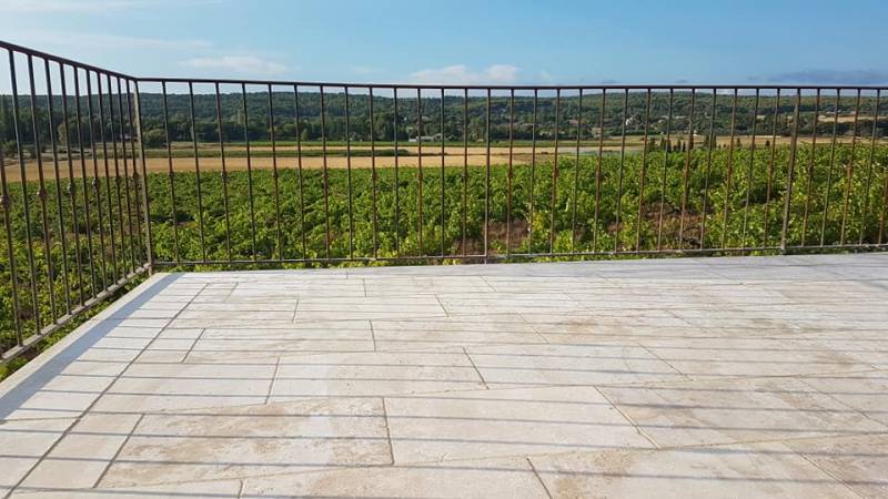 Terrasse de bastide, travertin et balustrade en fer forgé